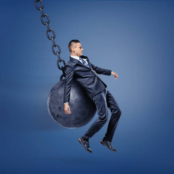 Бізнесмен потрапляє на спину зламаним м'ячем і піднімається над землею . — стокове фото