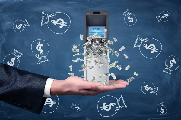 Un uomo d'affari tiene in mano un bancomat con banconote da un dollaro. . — Foto Stock