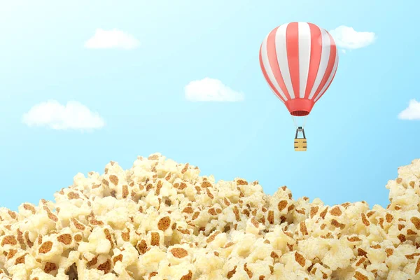 3d representación de un archivado cubierto con palomitas de maíz con un globo aerostático rayado volando sobre él . — Foto de Stock