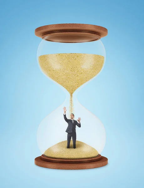 Sandglass met zand gieten van de bovenste bol op zakenman in lagere lamp — Stockfoto