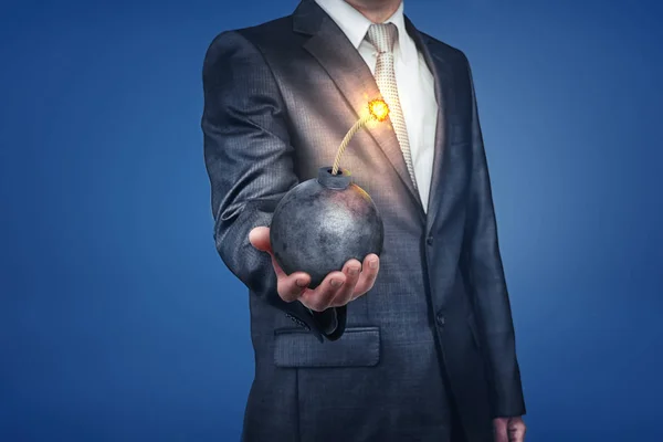 Homme d'affaires avec bombe à la main sur fond bleu — Photo