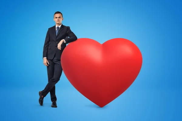 Homme d'affaires et grand modèle de coeur rouge sur fond bleu — Photo