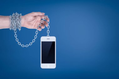 Erkek el mavi zemin üzerine beyaz akıllı telefon zincirlenmiş