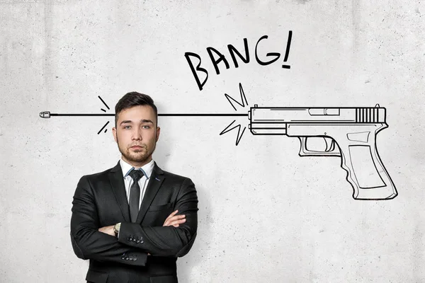 Mladý podnikatel s Bang znamení a karikatura zbraň Střelba nakreslené na zdi bílé pozadí — Stock fotografie