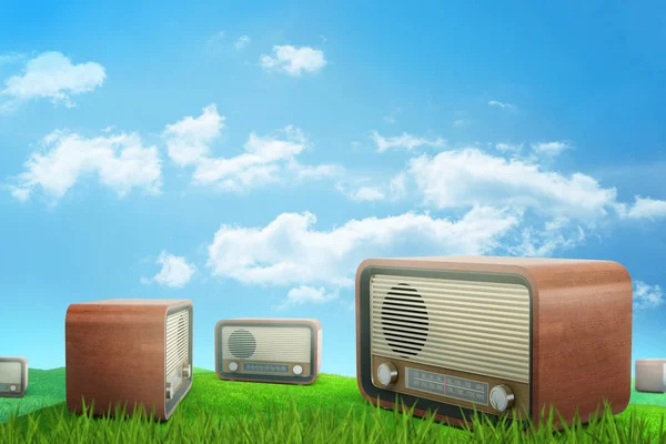 3D renderização de vários conjuntos de rádio retro marrom no prado verde iluminado pelo sol sob o céu azul com nuvens brancas . — Fotografia de Stock