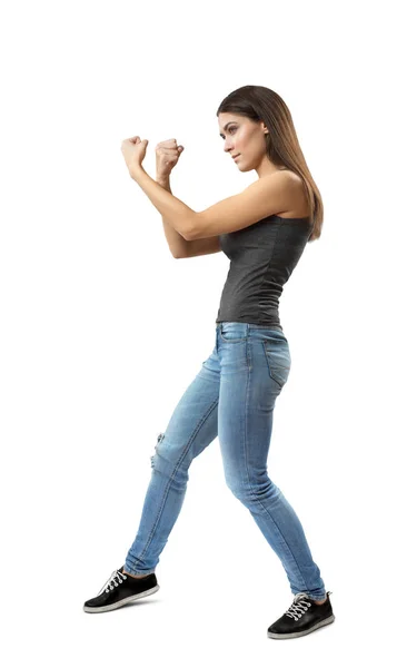 Rahat kot pantolon ve t-shirt çift yumruk gösterilen giyen genç esmer kız beyaz arka plan üzerinde izole jest — Stok fotoğraf