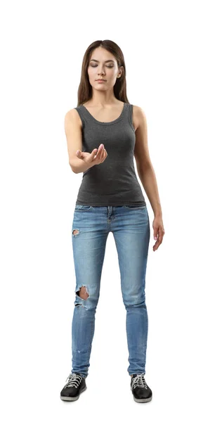 Νεαρή μελαχρινή κοπέλα που φοράει casual τζιν και t-shirt κοιτάζοντας το χέρι της σε λευκό φόντο — Φωτογραφία Αρχείου