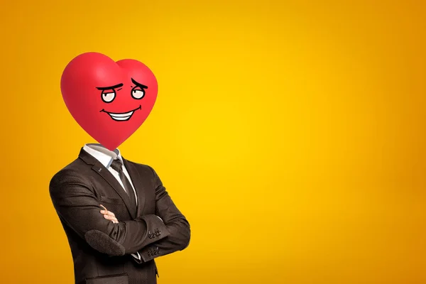 Homme d'affaires avec bande dessinée rouge coeur souriant au lieu de la tête sur fond jaune — Photo