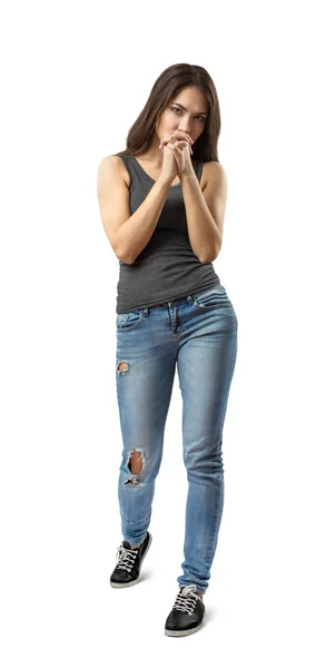 Junges brünettes Mädchen trägt lässige Jeans und T-Shirt, das die Finger auf weißem Hintergrund verschränkt — Stockfoto