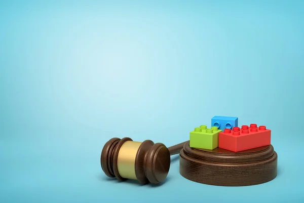 3D rendering van kleurrijke Lego stukjes op ronde houten blok en bruine houten Gavel op blauwe achtergrond — Stockfoto