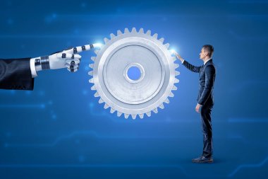 Bir tarafta robotik eli olan büyük gri dişli ve mavi arka planda diğer tarafta bir işadamı