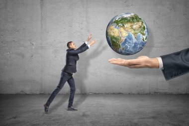 Sağdan çıkan büyük insan eli üzerinde levitated dünya gezegeni için uzanan küçük işadamı yan görünümü.