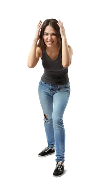 Vista frontal de la hermosa mujer en la parte superior gris y pantalones vaqueros azules de pie y inclinados hacia adelante, con las manos en la cabeza, sonriendo y arrugando la nariz en el fondo blanco . —  Fotos de Stock