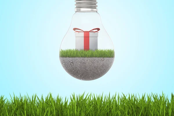 Closeup de lâmpada com terra, grama e caixa de presente dentro, pendurado acima do gramado verde . — Fotografia de Stock