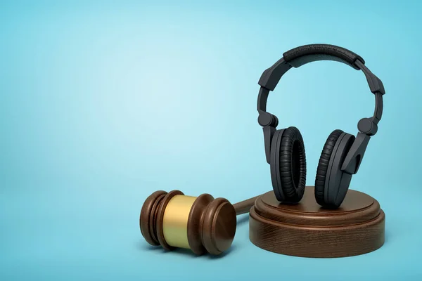 3D renderização de fones de ouvido pretos em pé no bloco de som com martelo juiz ao lado no fundo azul-claro . — Fotografia de Stock