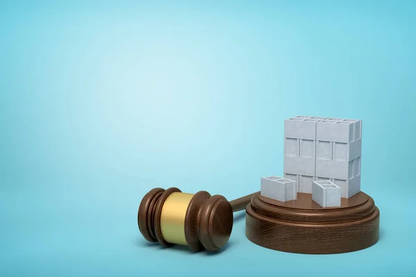 3D-rendering van de stapel grijze holle bakstenen op klinkende blok met rechter Gavel liggend naast op licht blauwe achtergrond. — Stockfoto