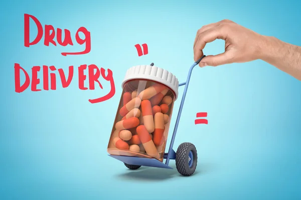 Mano tenendo piccolo camion mano con vaso di plastica pieno di pillole mediche e Drug Delivery segno su sfondo blu — Foto Stock