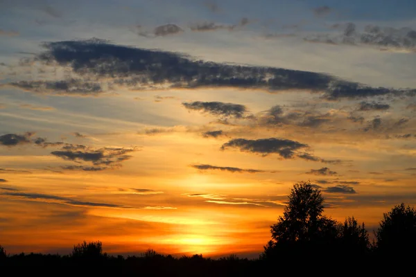 Foto de uma paisagem rural de verão com pôr do sol — Fotografia de Stock