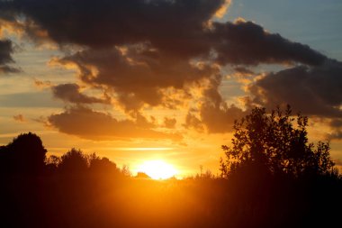 Yaz akşamları bulutlu bir alanın üzerinde parlak bir günbatımı güzel fotoğraf