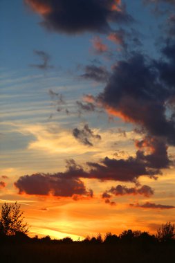 Yaz akşamları bulutlu bir alanın üzerinde parlak bir günbatımı güzel fotoğraf