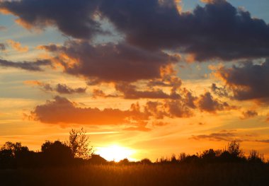 Yaz akşamları bulutlu bir alanın üzerinde parlak bir günbatımı güzel fotoğraf