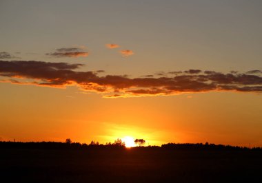 Yaz akşamları bulutlu bir alanın üzerinde parlak bir günbatımı güzel fotoğraf