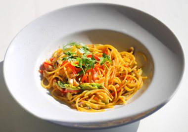 Makro fotoğraf beyaz bir tabakta sebze ile lezzetli makarna