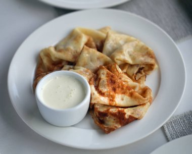 Vanilya beyaz bir tabağa krem ile ince lezzetli gözleme makro fotoğraf