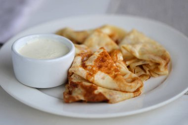 Vanilya beyaz bir tabağa krem ile ince lezzetli gözleme makro fotoğraf