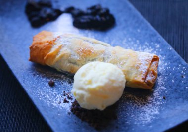 Makro fotoğraf parlak böğürtlenli turta ve dondurma karanlık bir plaka üzerinde