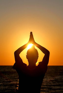 Güneşin arka planında gün batımında bir kızın siluetfotoğrafı