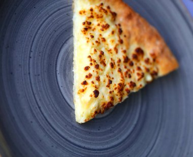 Kafede tabağında peynir olan bir dilim pizzanın fotoğraf deseni.