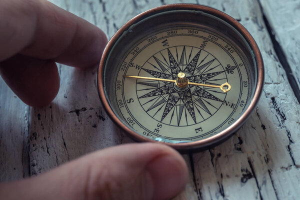 Old vintage compass on rustic wooden background