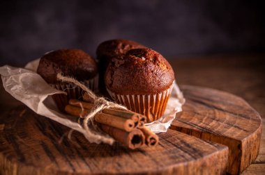 Rustik ahşap arka plan taze çikolatalı kekler ve tarçın çubukları