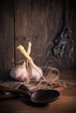 Çuval bezi ve ahşap ile kırsal arka plan üzerinde sarımsak iki baş