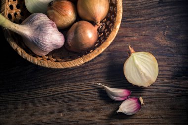 Çuval bezi ve ahşap ile kırsal arka plan üzerinde sarımsak iki baş