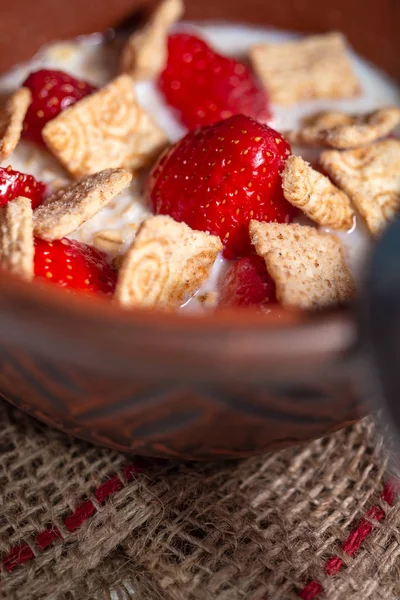 Rustik masada çilek ve tahıl yastıkları ile yulaf ezmesi lapası Kase
