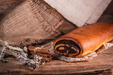 Haşhaş tohumu rulosu, ahşap arka planda ev yapımı kek.