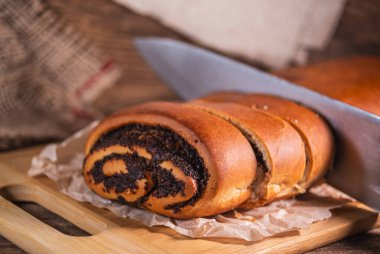 Haşhaş tohumu rulosu, ahşap arka planda ev yapımı kek.