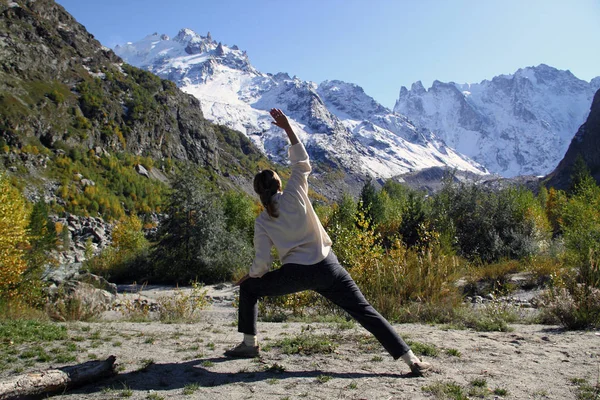 Frau praktiziert Yoga in einer Bergschlucht. Reiselebensstil entspannen — Stockfoto