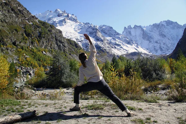 Een vrouw beoefent yoga in een bergkloof. Reizen Lifestyle Relax Stockfoto