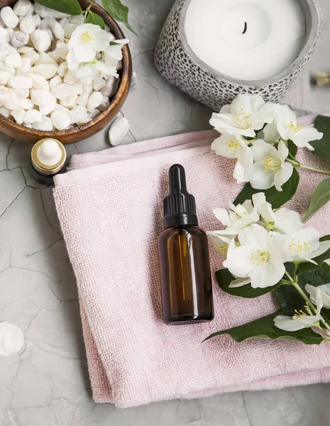Spa natürmort jasmin yağı, çiçek, banyo tuzu ve havlu. Sağlıklı yaşam ve spa flatlay ayarı