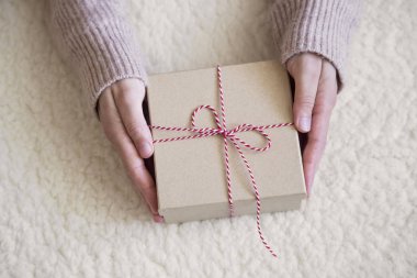 Kırmızı ve Beyaz Kurdeleli Kırsal Noel Hediyesi Tutan Kadın