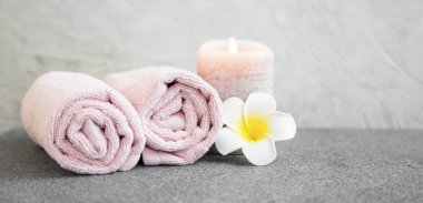 Spa natürmort ayarıyla havlu, frangipani çiçek ve mum beton zemin üzerine