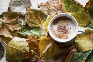 Sonbahar kahve fincanı, kurutulmuş yaprakları, üstten görünüm ile cappuccino kahve kompozisyon düşmek
