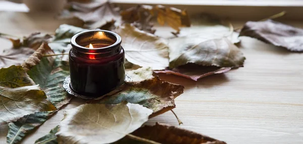Fall scented candle with dried leaves decoration, interior fall scented candle