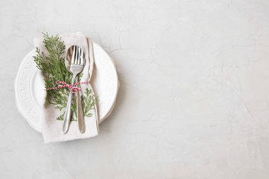 Noel tablo ayarı ile kopya alanı beton zemin üzerine tabak ve çatal bıçak takımı ve köknar ağacı süsle