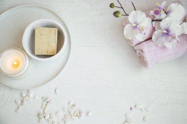 Spa natürmort ayarıyla orkide çiçek, doğal sabun, havlu ve mum, spa ve aromaterapi natürmort beton arka plan en iyi görünümde ayarlamak