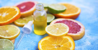 Citrus oil bottle with lime, orange, lemon and grepfruit slices, organic herbal botanical citrus extracts oil