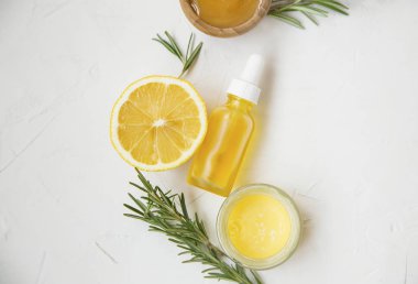 Organik Cilt Bakımı malzemelerle limon ve biberiye yağı şişe ve ot, manuka tatlım ve Melisa merhem, beyaz arka plan üzerinde üstten görünüm